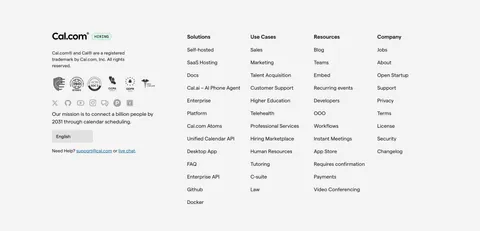 Cal.com footer section: logo, compliance badges, social icons and language selector beside four link columns on light gray