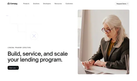 Canopy hero section: left-aligned headline with eyebrow and button beside a photo of a woman working on a laptop