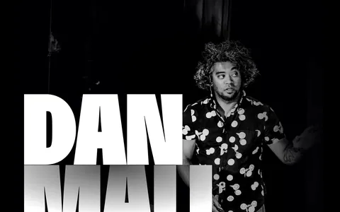 Dan Mall footer section: huge name beside a portrait photo, pink newsletter form band, social stats and flowers on black