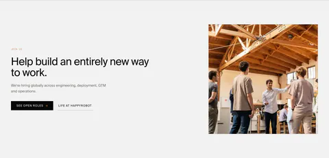 HappyRobot careers section: Join us eyebrow, headline and two buttons on the left, photo of a team in a timber-roofed office on the right